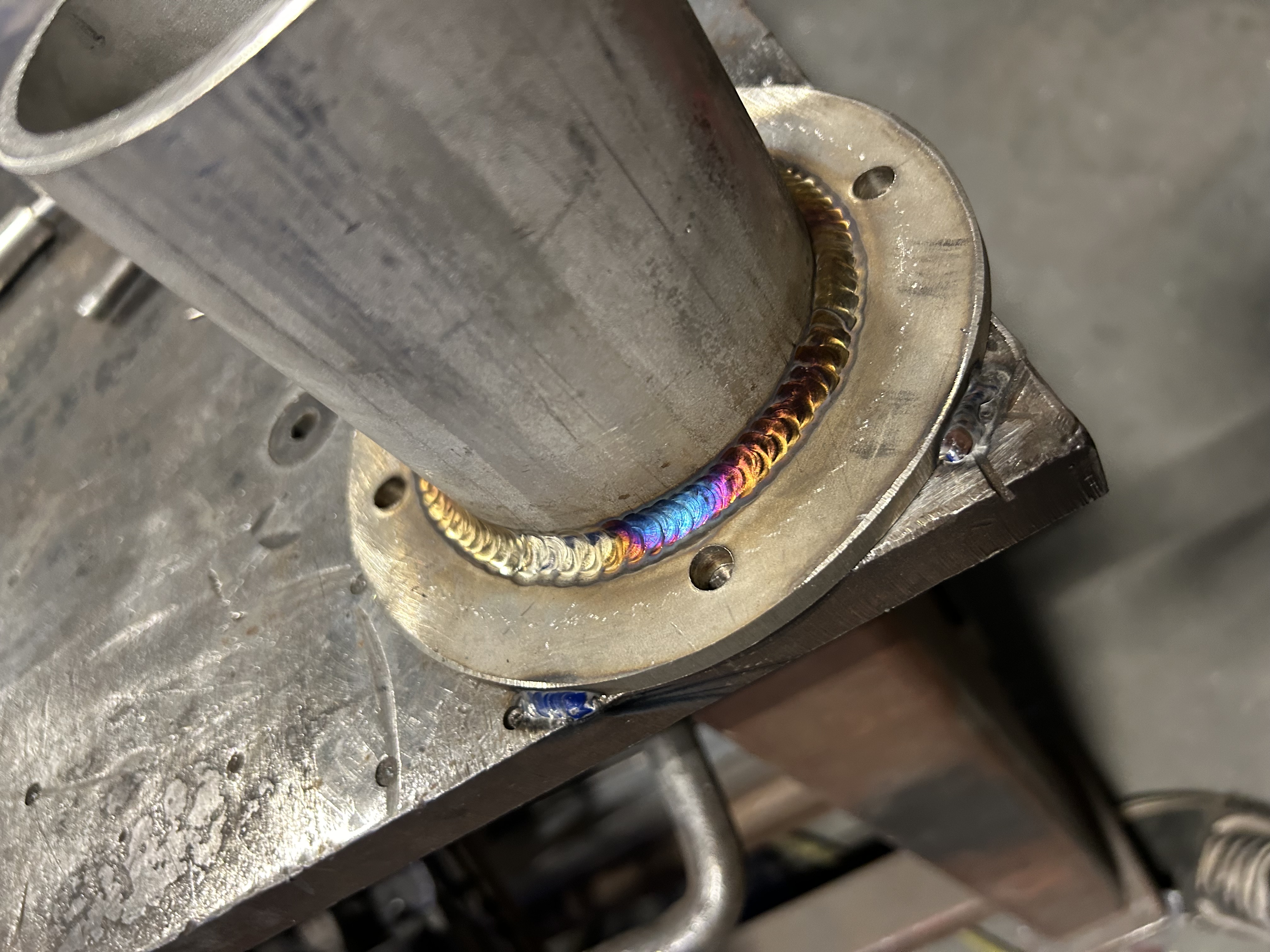 Close-up of a clean, finished weld bead on a steel flange